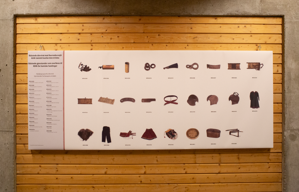 Utstillingsdetalj: Foto av samiske tradisjonsgjenstander på ei stor tavle hengt opp på vegg